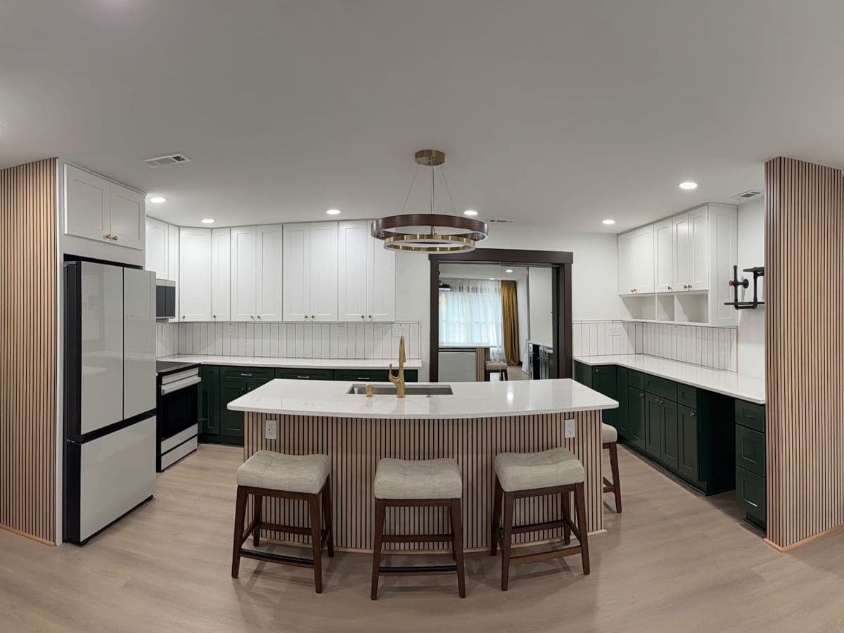 Remodeled kitchen with green cabinets, white quartz island and slat wood accents