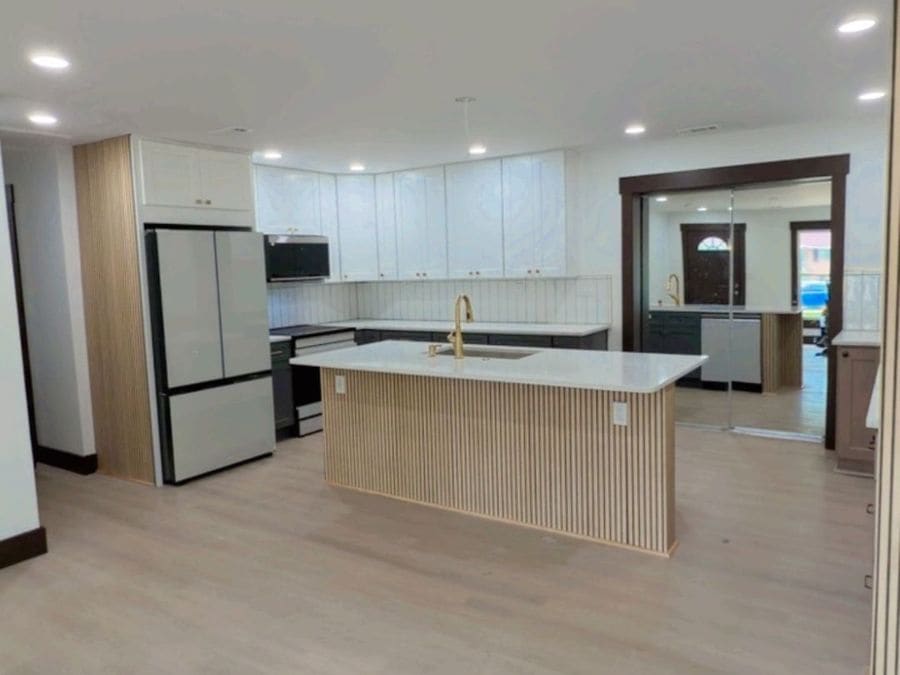 Open-concept kitchen and living area with new flooring and custom island